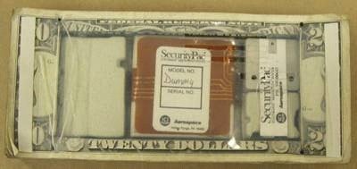 Figure 1 is a bank security dye pack. The stack of bills contains an electronic device disguised within a hollowed portion of the stack.