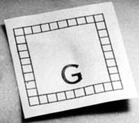 Close-up photograph of the paper scale shown in Figure 1, which features a capital letter G and a square frame composed of many smaller squares.