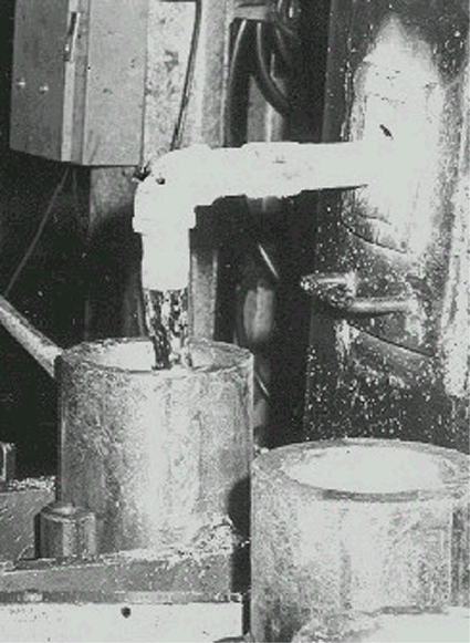 Photograph of lead being poured into billet mold.