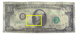 Figure 2A is a photograph of a chemically treated latent fingerprint developed on the dark region of a counterfeit $10 bill. 
