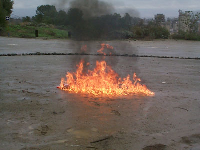Figure 2 is a photograph of a plastic gas can engulfed in flames.