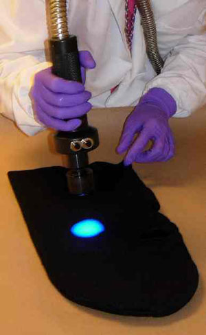 A photograph showing an examiner performing a preprocessing screen using an alternate light source