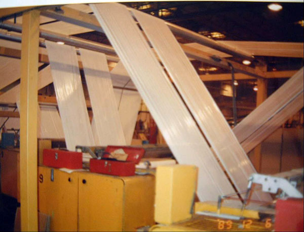 Figure 3: A photograph of a series of rollers flattening the plastic into long sheets and transporting it through the manufacturing process 