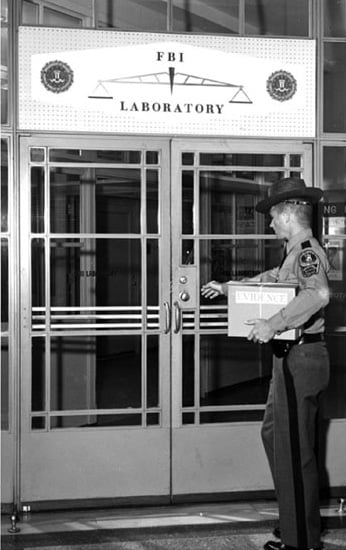 A historical photo of a Virginia State Police Officer delivering evidence to the Laboratory