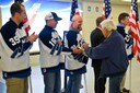 On May 7, 2014, members of the FBI Chicago hockey team and other employees welcomed home a group of WWII veterans returning from an Honor Flight trip to Washington, D.C. For the last three years, members of the FBI Chicago Field Office have skated against a Chicago Police Department team in a hockey game hosted by Honor Flight Chicago. The Law Enforcement Hockey Classic is sponsored by Honor Flight Chicago and the FBI Agents Association to raise money for veterans to enjoy an all expenses paid trip to visit the WWII memorial in Washington.